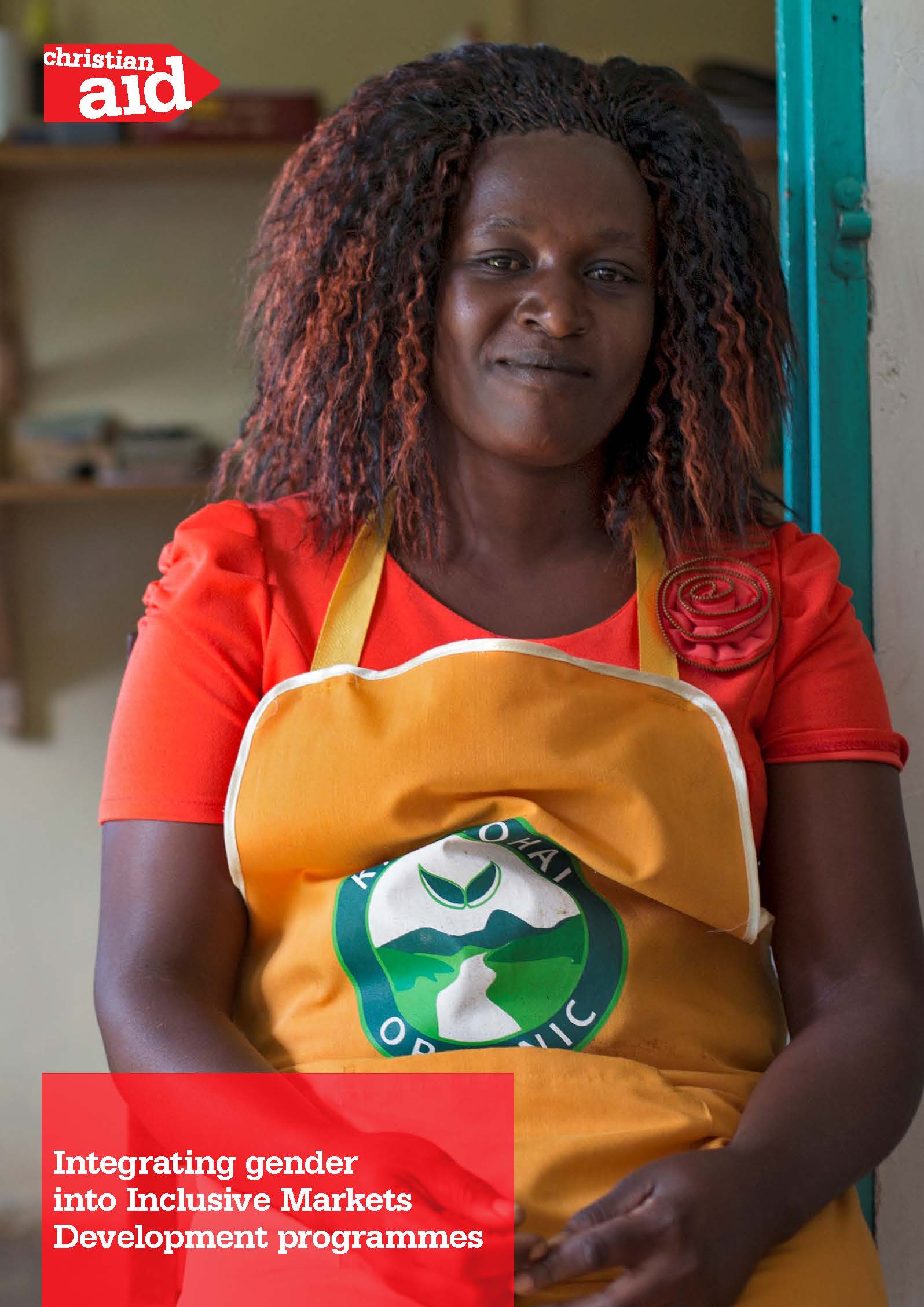 Woman standing towards camera, wearing apron and smiling.